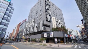 Un immeuble moderne de grande hauteur, doté de nombreux étages, de grandes fenêtres et d’une entrée imposante avec une enseigne.