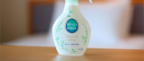 Botella pulverizadora con etiqueta sobre una superficie de madera.