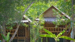 Two thatched-roof huts surrounded by lush greenery. - The Ford Sunset Beach Resort (Ko Pha-ngan)