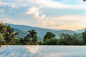 Piscina all'aperto, una piscina a sfioro, lettini
