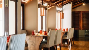 A dining area with a wooden table, striped chairs, and pendant lighting. - Mount Havana (Udapalatha)