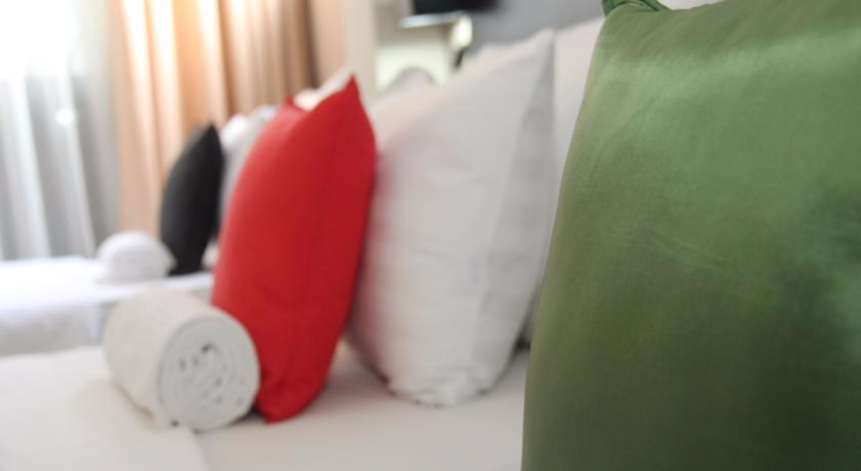 Uma cama com almofadas num quarto de hotel.
