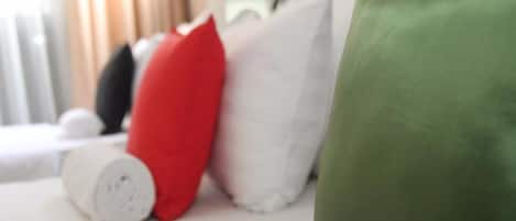 Uma cama com almofadas num quarto de hotel.