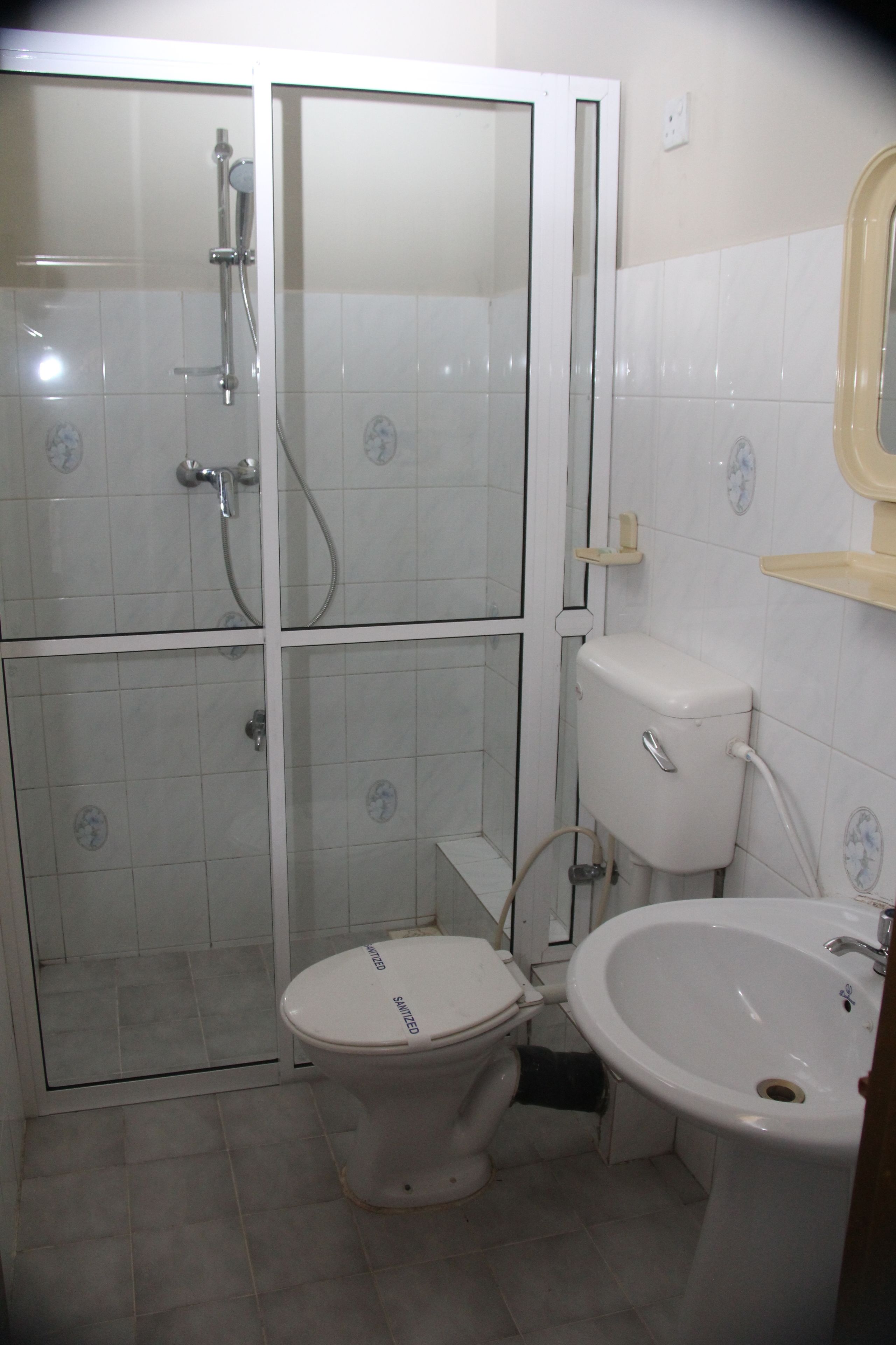 A bathroom with a toilet, a sink, and a shower.