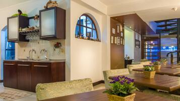 Una cocina moderna con armarios de madera oscura, una estantería para vinos empotrada y un amplio ventanal de arco.