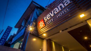 Das äußere Erscheinungsbild des Sevana City Hotels mit einem gut sichtbaren Schild und einem Apothekenzeichen im Hintergrund.