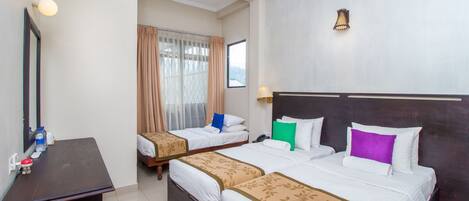 Een hotelkamer met twee enkele bedden, een bureau, een spiegel en een raam met gordijnen.
