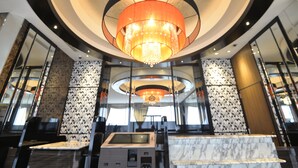 A modern lobby with a large chandelier, marble columns, and a reception desk. - APA Hotel Kagoshima Tenmonkan (Kagoshima)