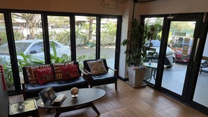 Un intérieur moderne avec un canapé, une petite table et une grande fenêtre donnant sur la rue.