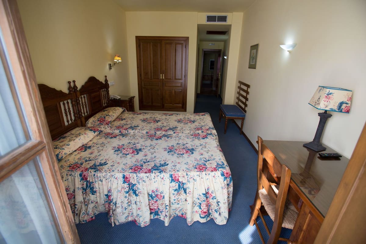 Une chambre à coucher avec un grand lit, une commode en bois, un bureau et une chaise.