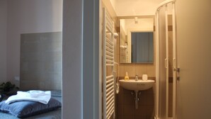 Een slaapkamer met een bed, een nachtkastje en een bedtafel.