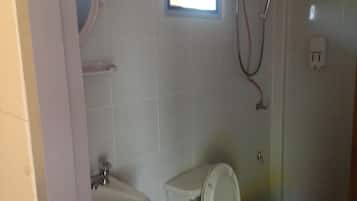 Un baño con inodoro, lavabo y ducha.