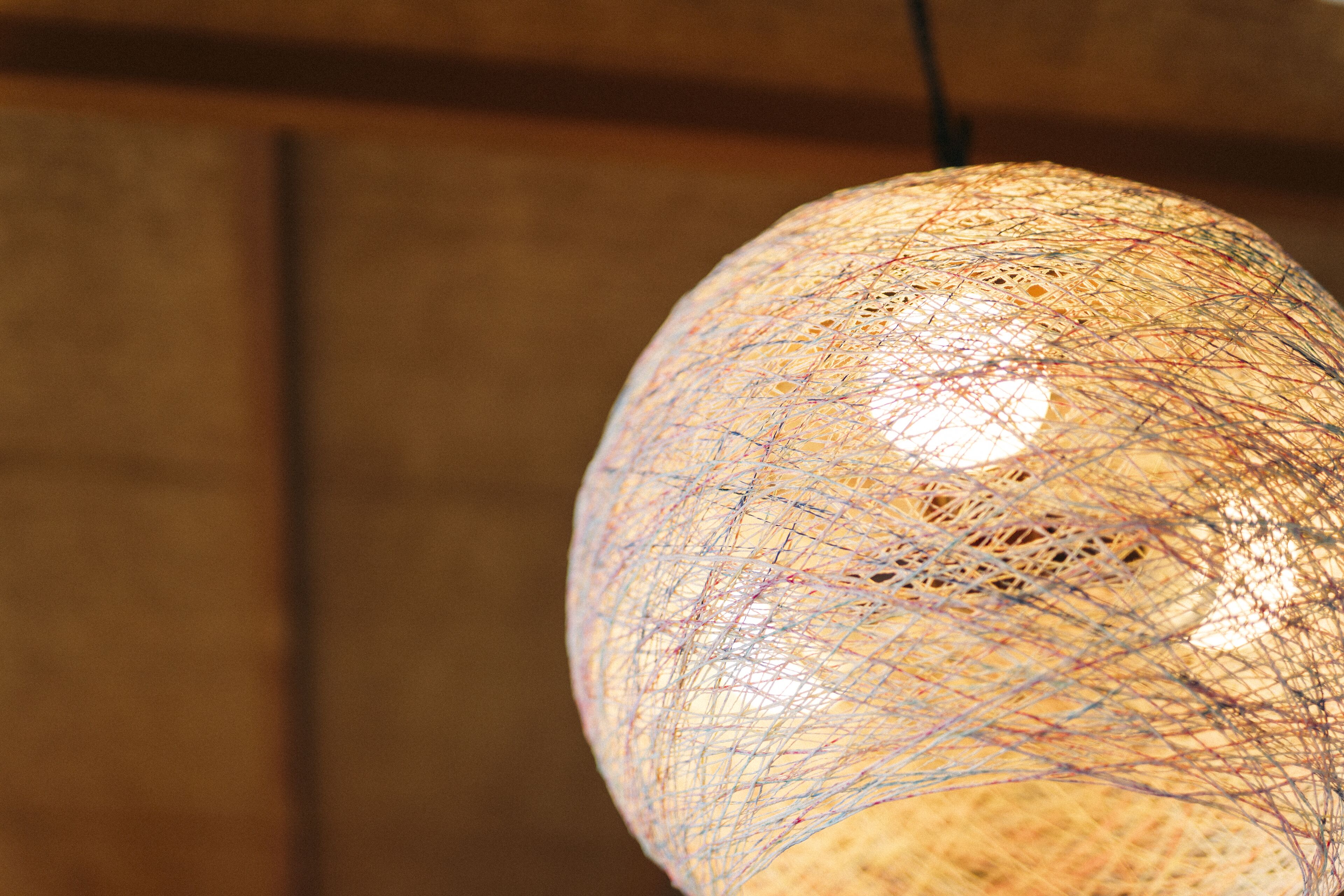 A spherical light fixture with a complex, web-like structure.