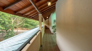 A corridor with wooden ceiling beams and a view of greenery outside. - Melheim Kandy Villas (Kandy)