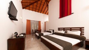 A hotel room with a large bed, a desk with a television, and a window with curtains. - Melheim Kandy Villas (Kandy)