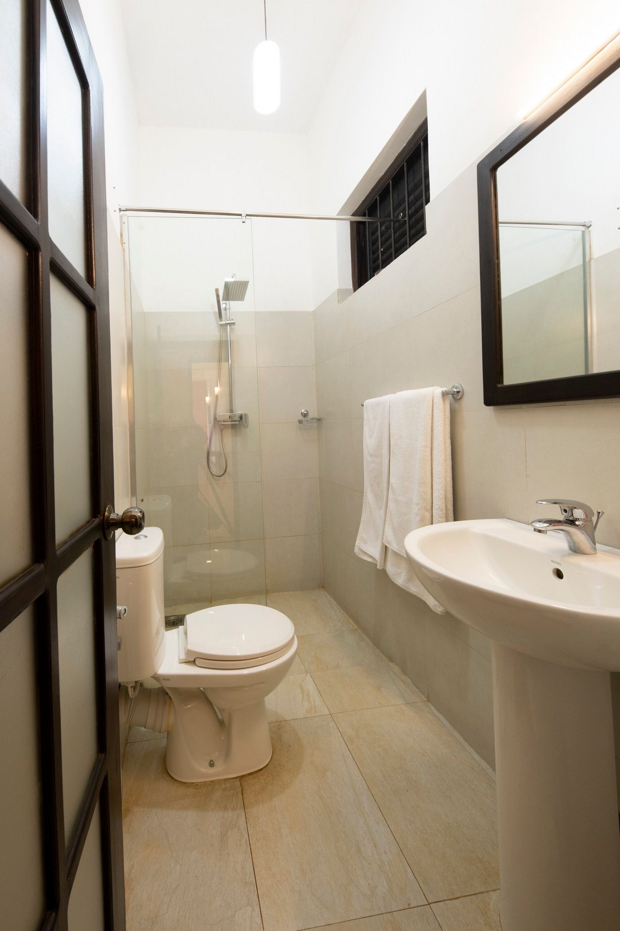 Un baño moderno con inodoro, ducha y lavamanos.