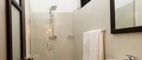 Un baño moderno con inodoro, ducha y lavamanos.