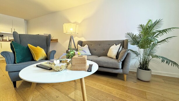 Un salon avec deux canapés, une table basse et une lampe.