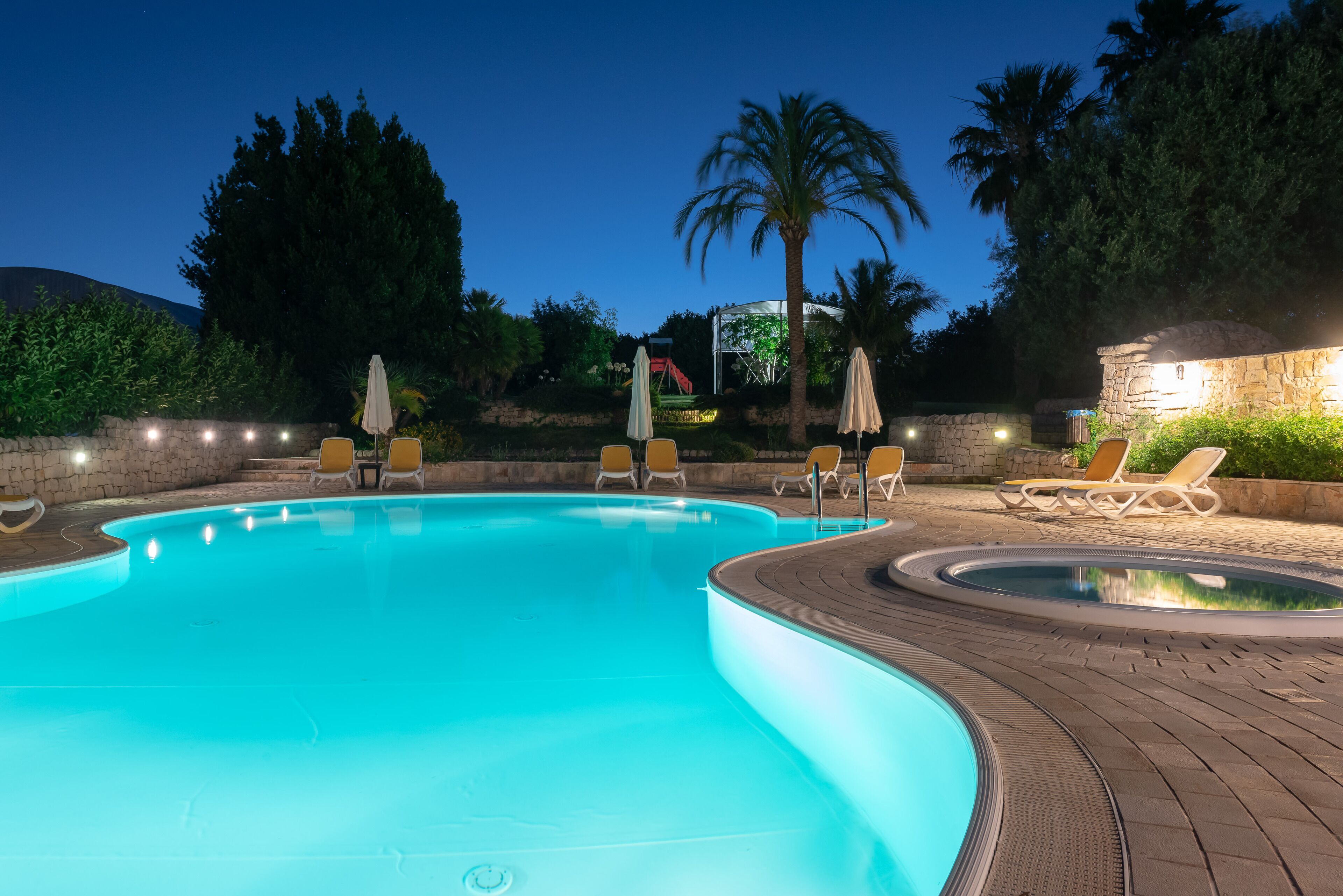 Una piscina al aire libre de temporada, sombrillas, tumbonas