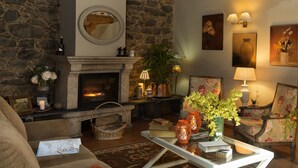 A cozy living room with a stone fireplace, wooden beams, and comfortable seating. - A Casa da Torre Branca (Santiago de Compostela)