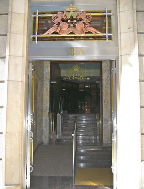 Una entrada imponente con una escalera de metal que conduce a una puerta con el número 16-A.