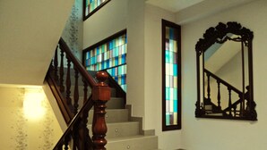 Una escalera con barandillas de madera, un pasamanos y un espejo fijado a la pared.