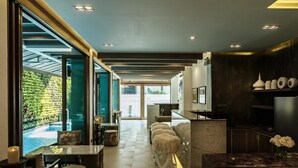Un interior modern amb vista a la piscina, una zona de bar i una cuina.
