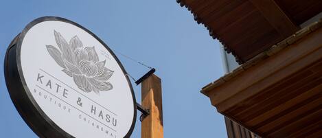 A circular sign with a lotus flower design and the text "KATE & HASU BOUTIQUE CHIANGMAI".