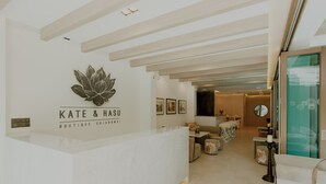 Zona de recepció d'un hotel boutique modern, amb un disseny minimalista que inclou taulell de recepció, zona de seients i obra d'art a les parets.
