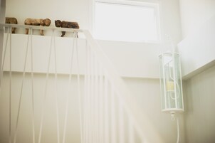 A room with a white ceiling, a window, and a hanging light fixture.