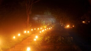 A pathway lined with lanterns leading to a building with a sloped roof. - Sigiriya Lodge - Hostel (Avudangawa)