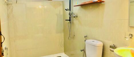 A bathroom with a shower, toilet, and sink.