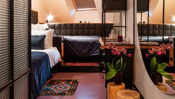 Un dormitorio moderno con una cama estilo altillo, un espejo grande y un taburete de madera.