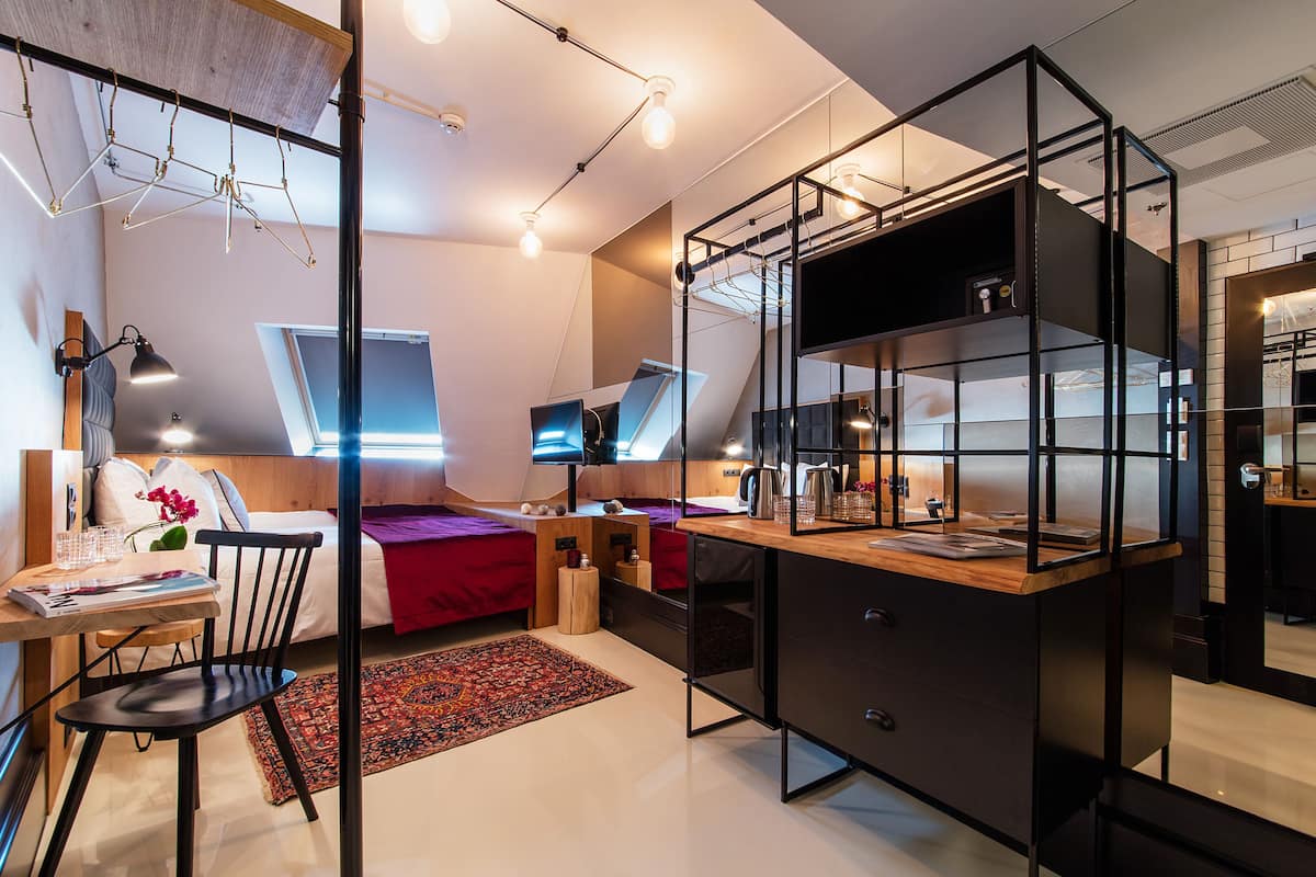 A modern bedroom with a desk, a bed, and a built-in wardrobe.