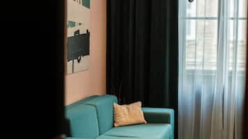 Una sala moderna con un sofá color turquesa, una mesita redonda y lámparas colgantes.