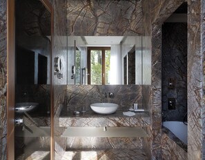 A modern bathroom with a marble vanity, a large mirror, and a bathtub. - Villa Lario Resort Mandello (Mandello del Lario)