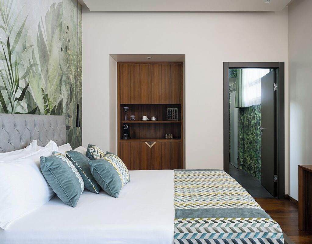 Ein modernes Schlafzimmer mit Bett, einem eingebauten Holzschrank und einer Glastür zum Balkon.