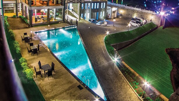 Un hotel con piscina, mobiliario exterior y vistas del entorno.