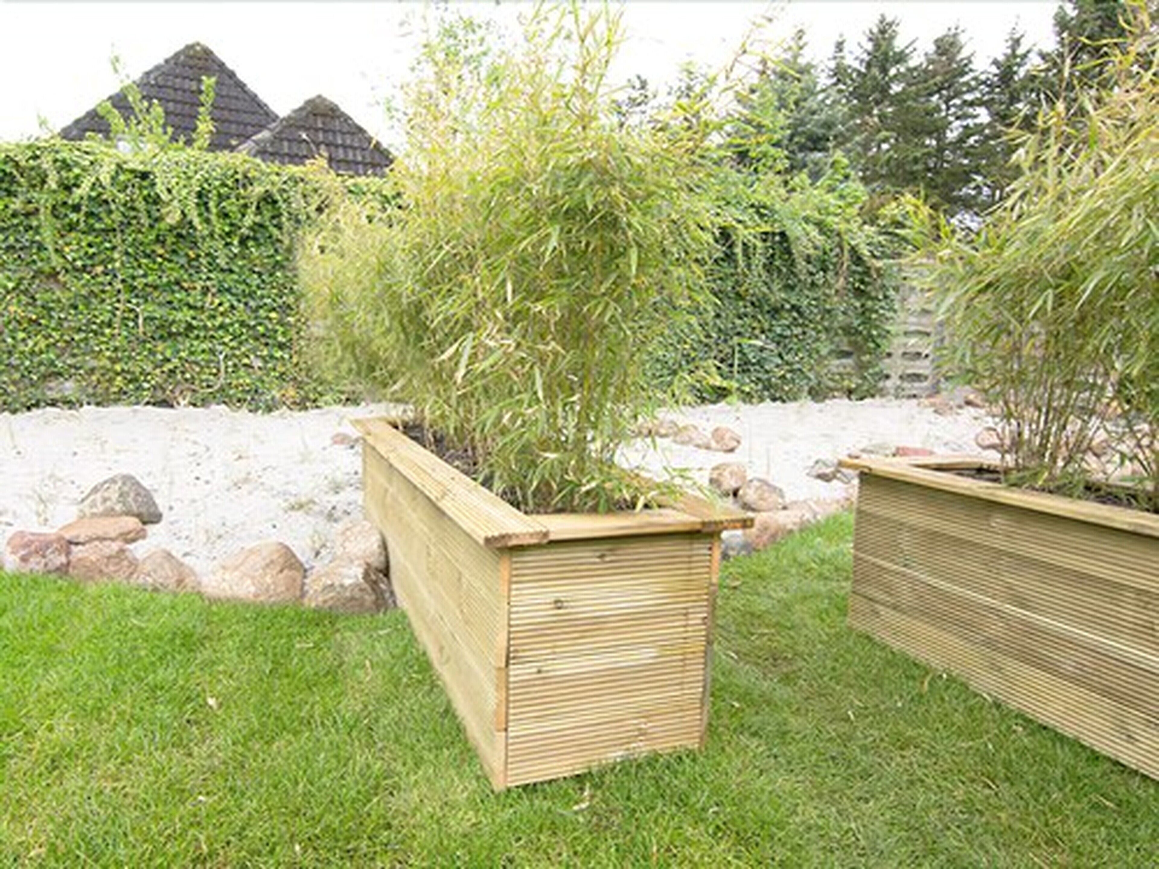 Two wooden planters with plants in a garden setting.