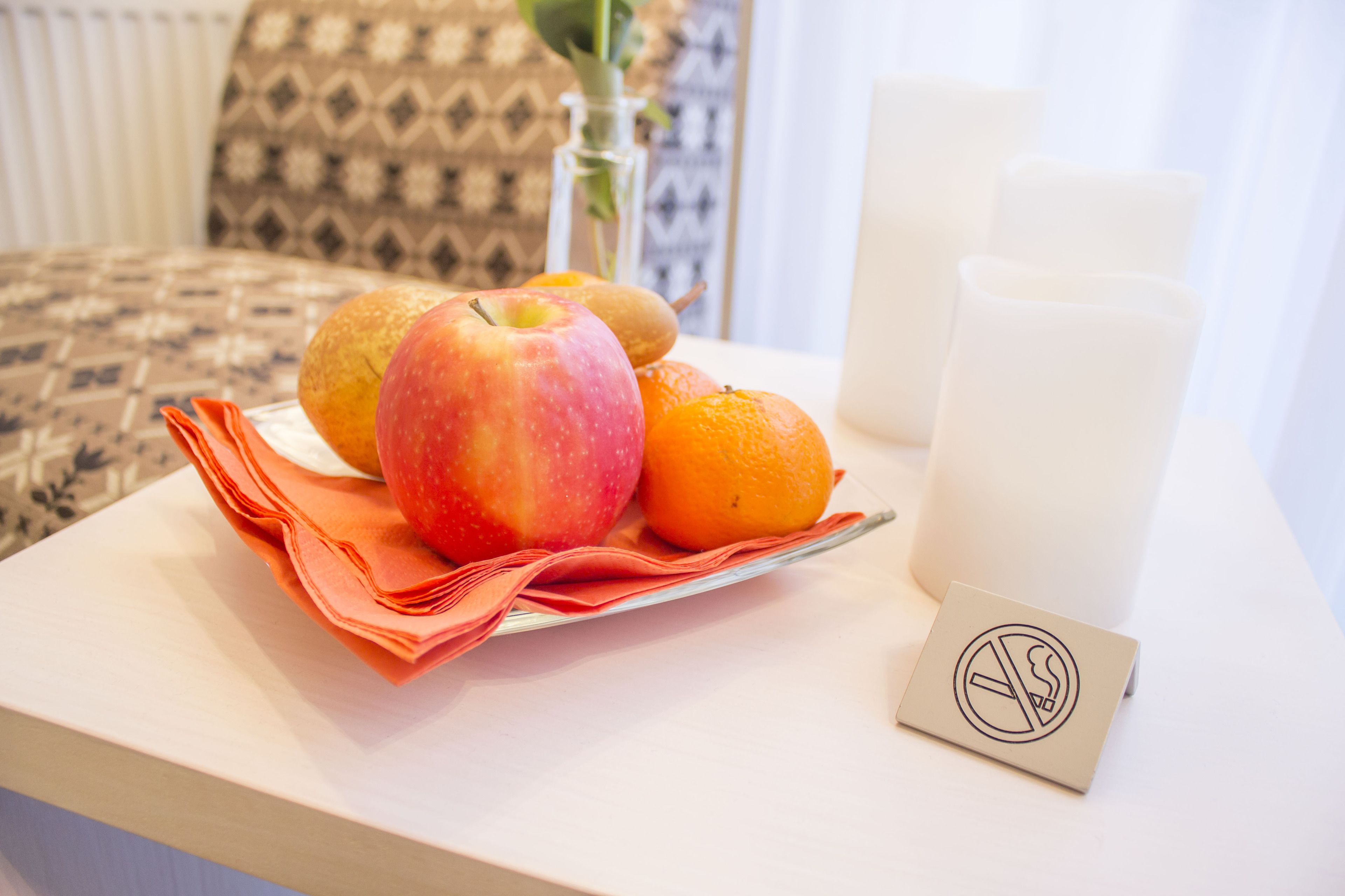 A table with fruits, a napkin, and a no-smoking sign.
