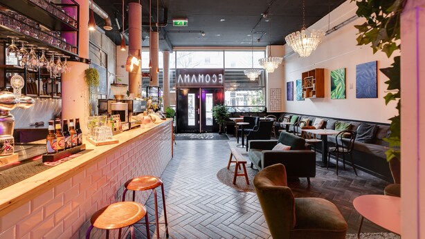 A modern bar area with a brick counter, stools, and hanging lights. - ClinkMama (Amsterdam)
