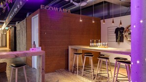 A reception area with a wooden counter, bar stools, and a neon sign. - ClinkMama (Amsterdam)