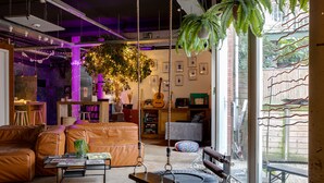 A cozy living room with a leather sofa, a coffee table, and a hanging swing. - ClinkMama (Amsterdam)