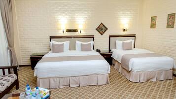 A hotel room with two beds, a brick-patterned wall, and a patterned carpet.