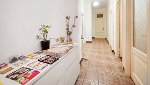Un pasillo con una exhibición de revistas y una planta en maceta.