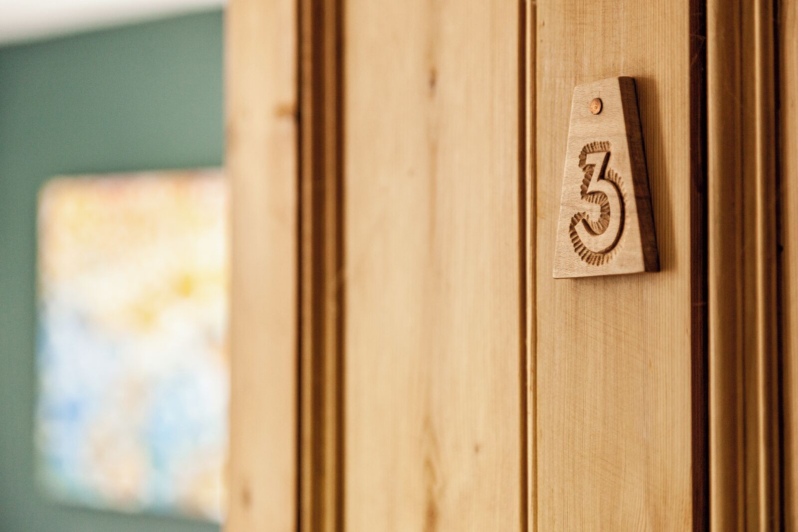 A wooden door with a number '3' sign.