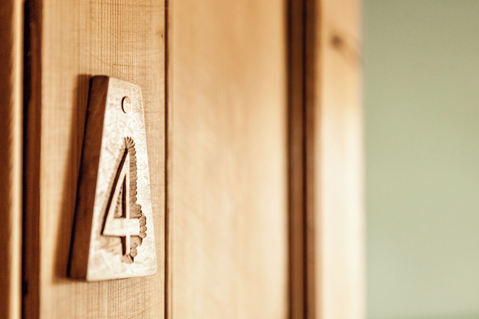 A wooden door with a number plate indicating room number 4.