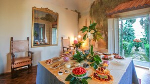A dining table with various food items and a mirror on the wall. - Villa Alta (San Giuliano Terme)