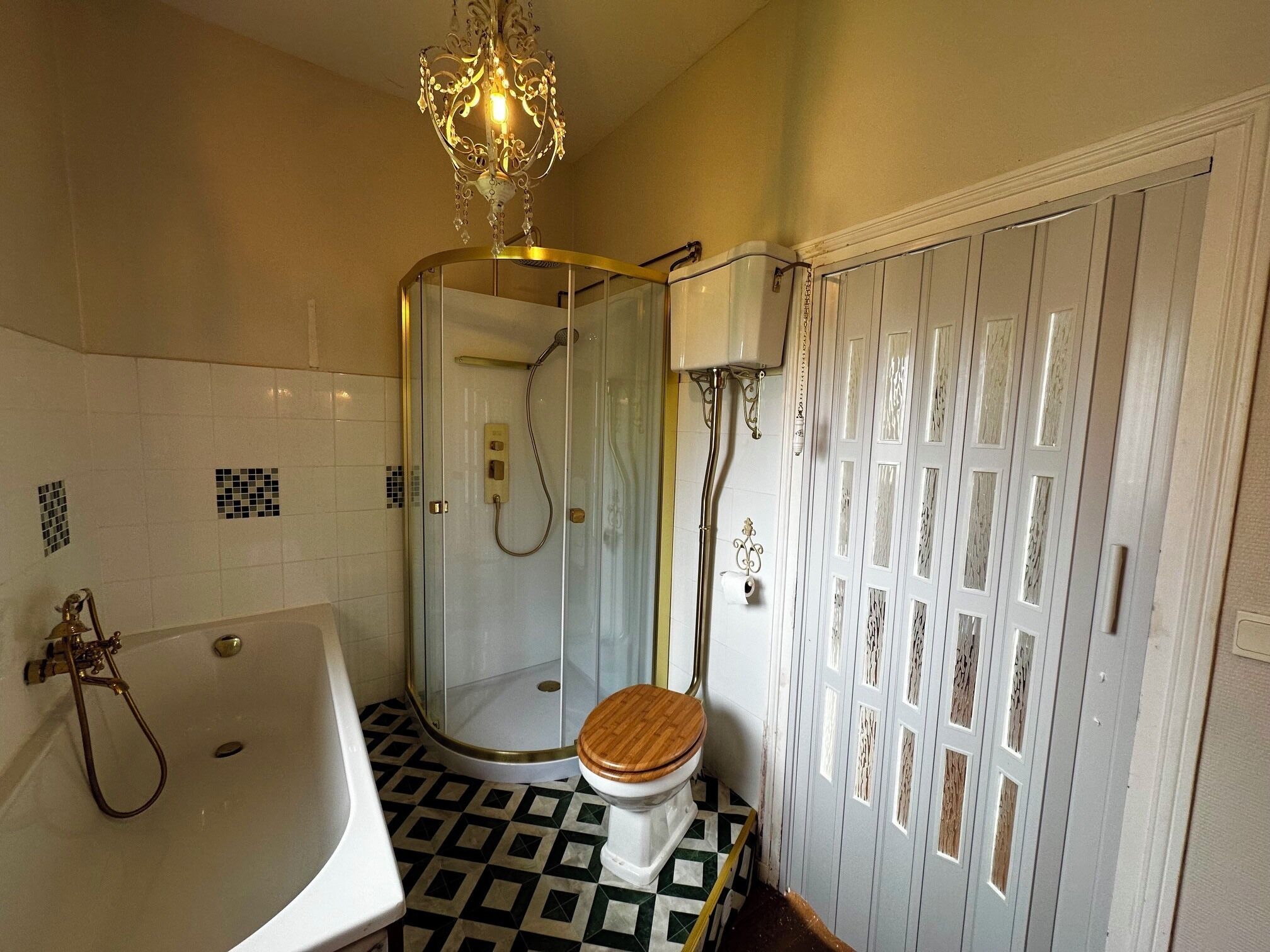 A bathroom with a bathtub, a glass-enclosed shower, and a toilet.