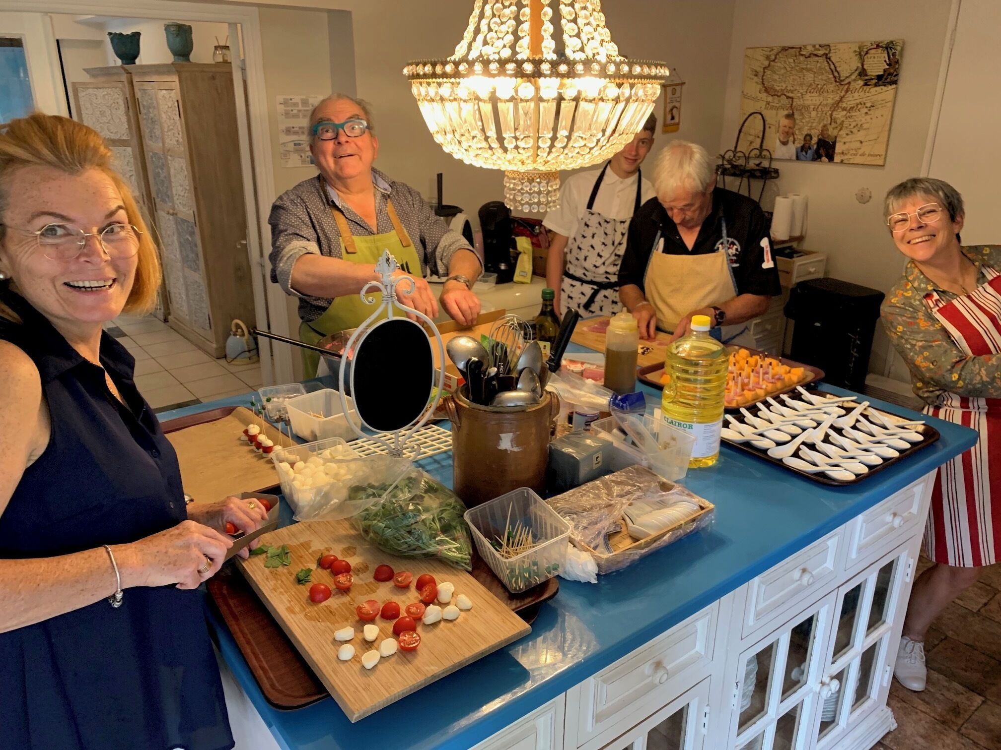 A kitchen with a blue countertop, a chandelier, and various food items.